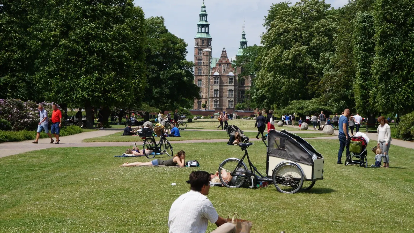 Människor i Kongens Have med Rosenborgs slott i bakgrunden